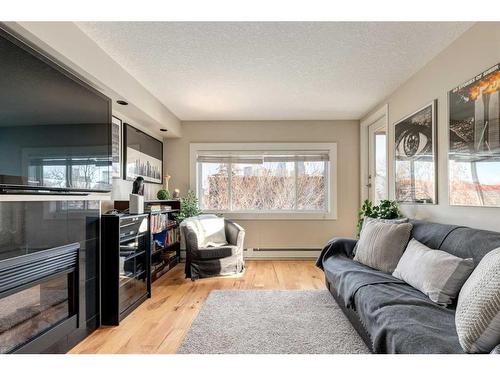 401-728 3 Avenue Nw, Calgary, AB - Indoor Photo Showing Living Room With Fireplace