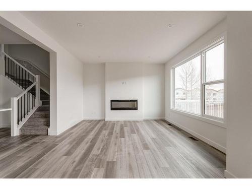 211 Silver Spruce Grove Sw, Calgary, AB - Indoor Photo Showing Other Room With Fireplace