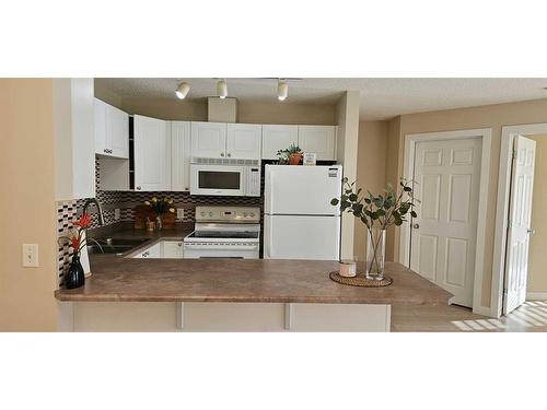 305-9 Country Village Bay Ne, Calgary, AB - Indoor Photo Showing Kitchen With Double Sink