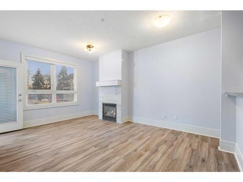 202-518 33 Street Nw, Calgary, AB - Indoor Photo Showing Living Room With Fireplace