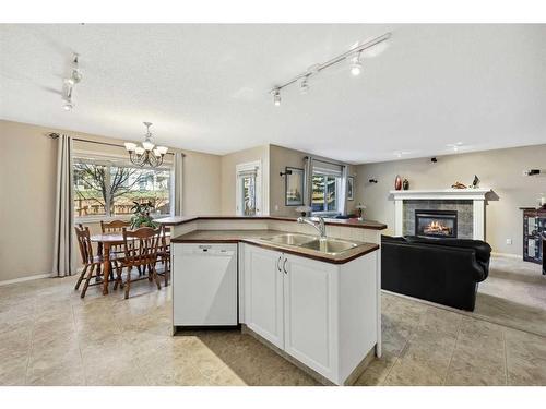 396 Rocky Ridge Drive Nw, Calgary, AB - Indoor Photo Showing Kitchen With Fireplace With Double Sink