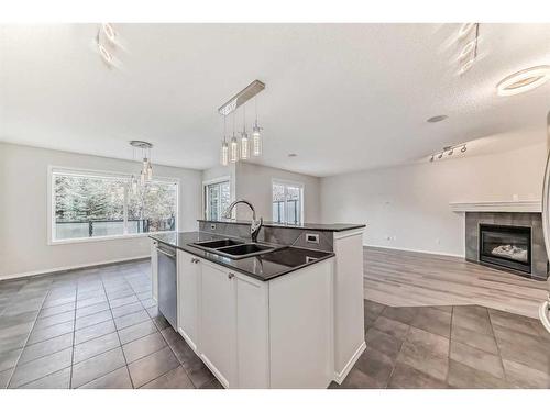 135 Cougarstone Square Sw, Calgary, AB - Indoor Photo Showing Kitchen With Fireplace With Double Sink