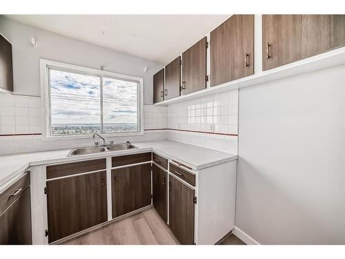 D-7540D Hunterview Drive Nw, Calgary, AB - Indoor Photo Showing Kitchen With Double Sink