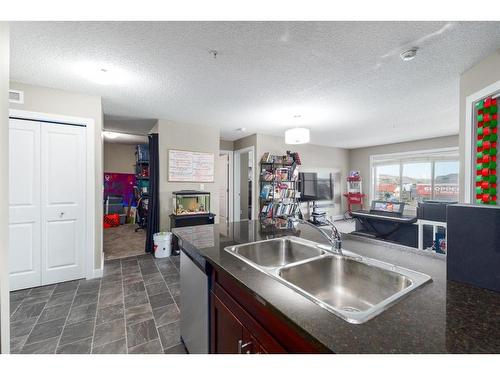 2410-625 Glenbow Drive, Cochrane, AB - Indoor Photo Showing Kitchen With Fireplace With Double Sink