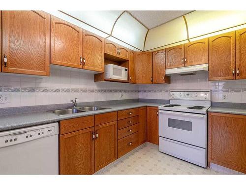 211-7239 Sierra Morena Boulevard Sw, Calgary, AB - Indoor Photo Showing Kitchen With Double Sink