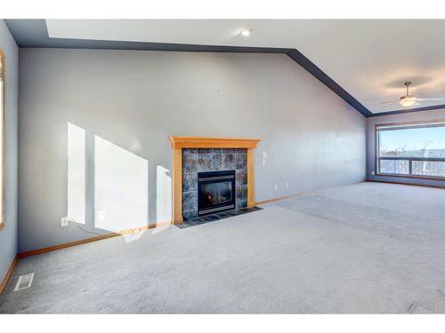 313 Robert Street Sw, Diamond Valley, AB - Indoor Photo Showing Other Room With Fireplace