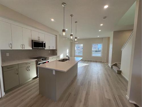 101 Riversong Boulevard, Cochrane, AB - Indoor Photo Showing Kitchen With Double Sink With Upgraded Kitchen