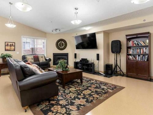 1111-200 Community, Okotoks, AB - Indoor Photo Showing Living Room With Fireplace