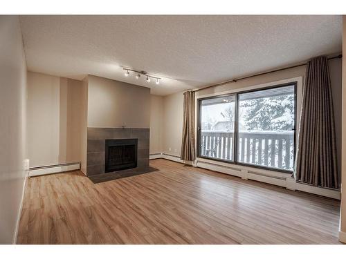 403-618 2 Avenue Nw, Calgary, AB - Indoor Photo Showing Living Room With Fireplace