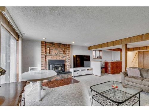 84 Range Way Nw, Calgary, AB - Indoor Photo Showing Living Room With Fireplace