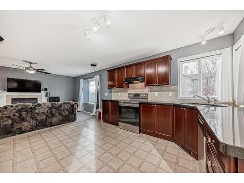 181 Luxstone Road Sw, Airdrie, AB - Indoor Photo Showing Kitchen With Fireplace