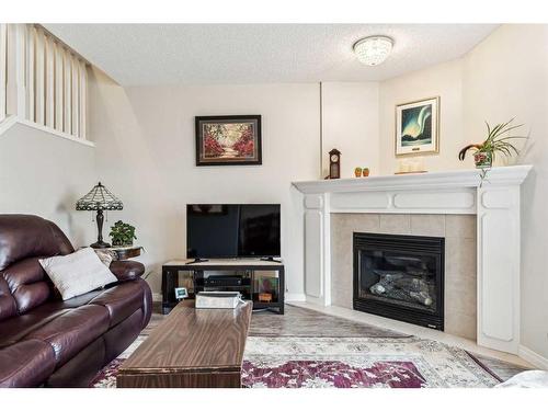 11-117 Bow Ridge Drive, Cochrane, AB - Indoor Photo Showing Living Room With Fireplace