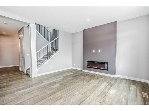 148 Sundown Crescent, Cochrane, AB - Indoor Photo Showing Other Room With Fireplace