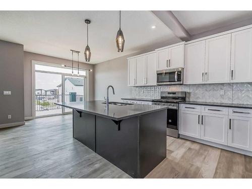 148 Sundown Crescent, Cochrane, AB - Indoor Photo Showing Kitchen With Upgraded Kitchen