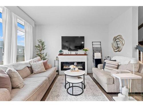 84 Sundown Manor, Cochrane, AB - Indoor Photo Showing Living Room With Fireplace