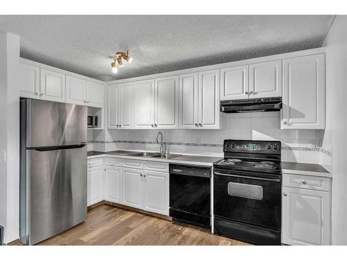 23A Ranchero Bay Nw, Calgary, AB - Indoor Photo Showing Kitchen With Double Sink