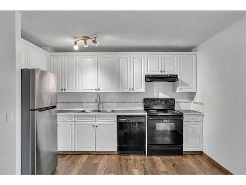 23A Ranchero Bay Nw, Calgary, AB - Indoor Photo Showing Kitchen With Double Sink