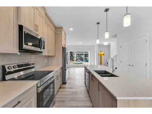 938 Cobblemore Common Sw, Airdrie, AB - Indoor Photo Showing Kitchen With Stainless Steel Kitchen With Double Sink With Upgraded Kitchen