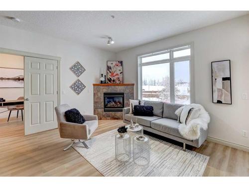 205-2 Hemlock Crescent Sw, Calgary, AB - Indoor Photo Showing Living Room With Fireplace