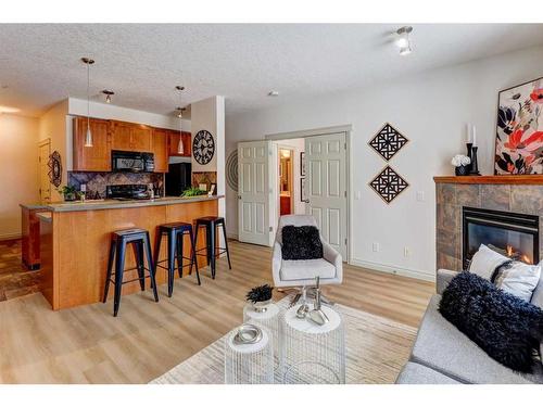 205-2 Hemlock Crescent Sw, Calgary, AB - Indoor Photo Showing Living Room With Fireplace