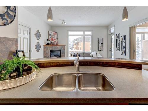 205-2 Hemlock Crescent Sw, Calgary, AB - Indoor Photo Showing Kitchen With Fireplace With Double Sink