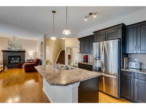 229 Cimarron Drive, Okotoks, AB - Indoor Photo Showing Kitchen With Fireplace With Stainless Steel Kitchen With Double Sink