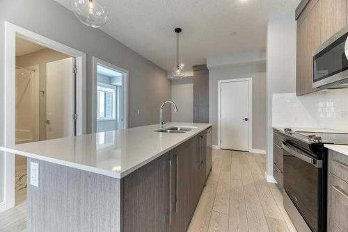 1409-111 Wolf Creek Drive Se, Calgary, AB - Indoor Photo Showing Kitchen With Double Sink With Upgraded Kitchen