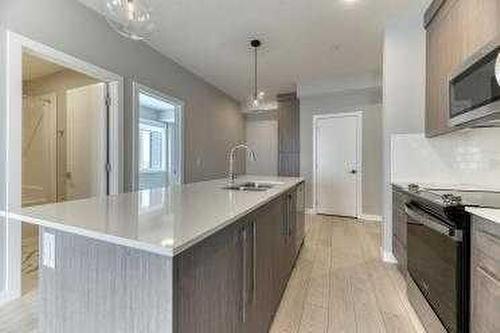 1409-111 Wolf Creek Drive Se, Calgary, AB - Indoor Photo Showing Kitchen With Upgraded Kitchen