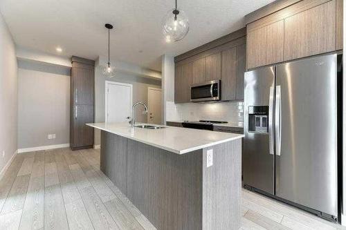 1409-111 Wolf Creek Drive Se, Calgary, AB - Indoor Photo Showing Kitchen With Double Sink With Upgraded Kitchen