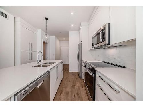 1201-111 Wolf Creek Drive Se, Calgary, AB - Indoor Photo Showing Kitchen With Stainless Steel Kitchen With Double Sink With Upgraded Kitchen