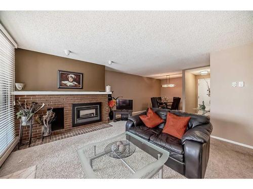 217-2425 90 Avenue Sw, Calgary, AB - Indoor Photo Showing Living Room With Fireplace