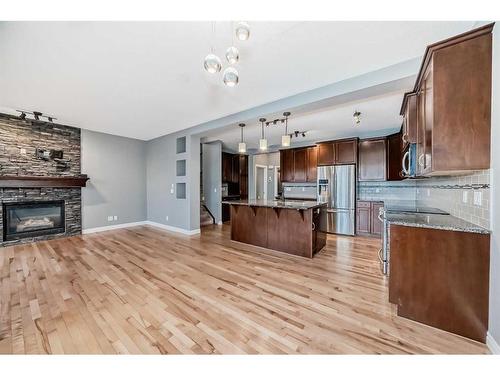 183 Hillcrest Circle Sw, Airdrie, AB - Indoor Photo Showing Kitchen With Fireplace