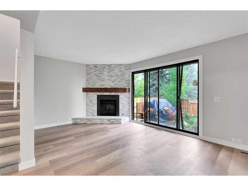 3-310 Brookmere Road Sw, Calgary, AB - Indoor Photo Showing Living Room With Fireplace