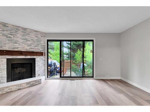 3-310 Brookmere Road Sw, Calgary, AB - Indoor Photo Showing Living Room With Fireplace