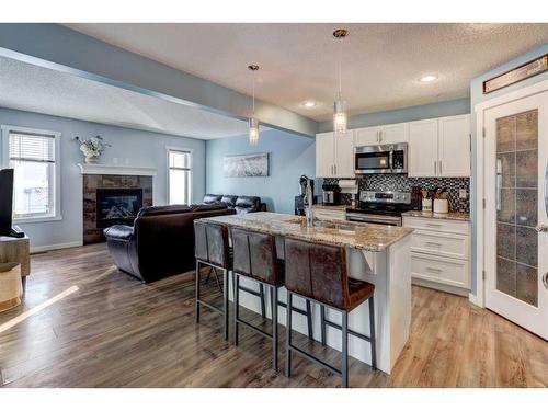 1227 Kings Heights Road Se, Airdrie, AB - Indoor Photo Showing Kitchen With Fireplace With Double Sink With Upgraded Kitchen