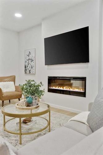 907 Langholm Drive Se, Airdrie, AB - Indoor Photo Showing Living Room With Fireplace