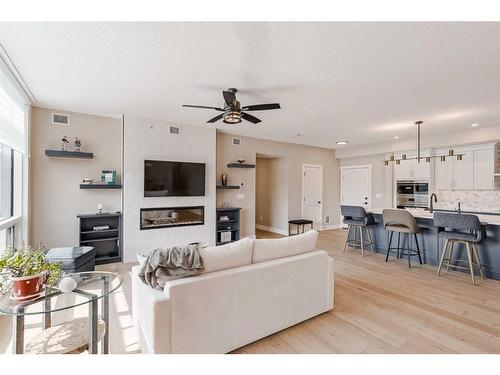 409-15 Cougar Ridge Landing Sw, Calgary, AB - Indoor Photo Showing Living Room With Fireplace