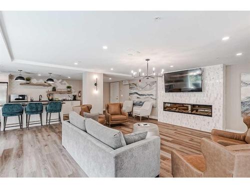 409-15 Cougar Ridge Landing Sw, Calgary, AB - Indoor Photo Showing Living Room With Fireplace