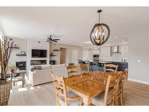 409-15 Cougar Ridge Landing Sw, Calgary, AB - Indoor Photo Showing Dining Room With Fireplace