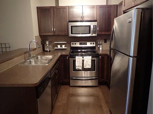 107-6315 Ranchview Drive Nw, Calgary, AB - Indoor Photo Showing Kitchen With Stainless Steel Kitchen With Double Sink