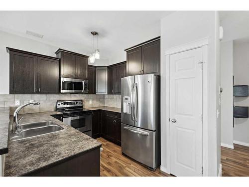 56 Arbours Circle Nw, Langdon, AB - Indoor Photo Showing Kitchen With Stainless Steel Kitchen With Double Sink With Upgraded Kitchen