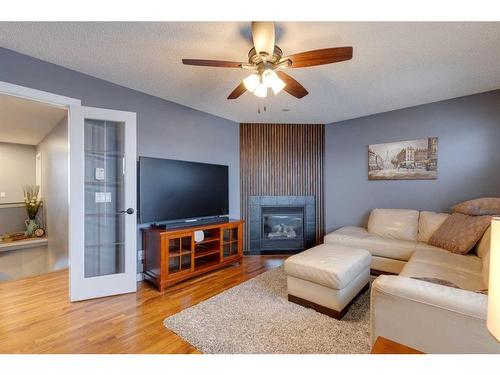 225 Cougar Ridge Drive Sw, Calgary, AB - Indoor Photo Showing Living Room With Fireplace