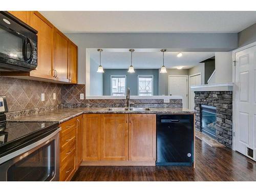 140 Elgin Point Se, Calgary, AB - Indoor Photo Showing Kitchen With Fireplace With Double Sink