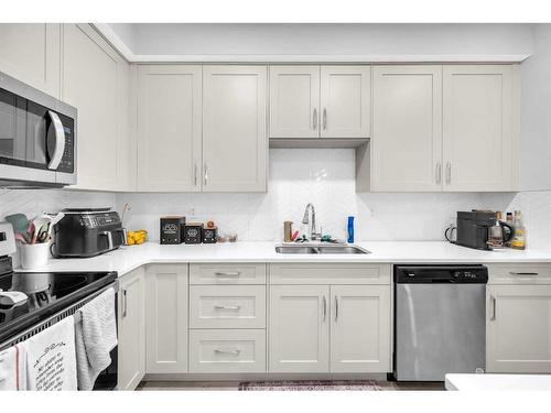 305-150 Shawnee Square Sw, Calgary, AB - Indoor Photo Showing Kitchen With Double Sink