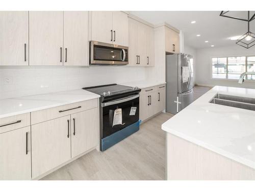 261 Midgrove Mews Sw, Airdrie, AB - Indoor Photo Showing Kitchen With Double Sink With Upgraded Kitchen