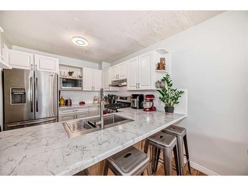 21-12 Silver Creek Boulevard Nw, Airdrie, AB - Indoor Photo Showing Kitchen With Double Sink