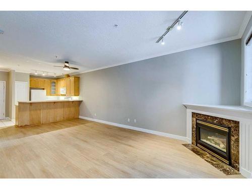 208-495 78 Avenue Sw, Calgary, AB - Indoor Photo Showing Living Room With Fireplace