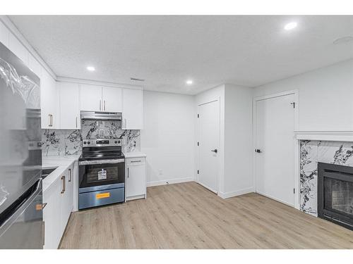 122 Sandstone Drive Nw, Calgary, AB - Indoor Photo Showing Kitchen With Fireplace With Upgraded Kitchen