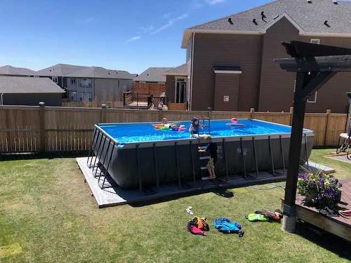 113 Heritage Cove, Cochrane, AB - Outdoor With Above Ground Pool With Backyard