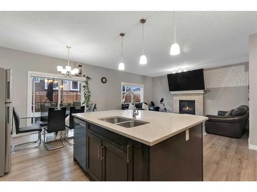 247 Kinniburgh Road, Chestermere, AB - Indoor Photo Showing Kitchen With Fireplace With Double Sink